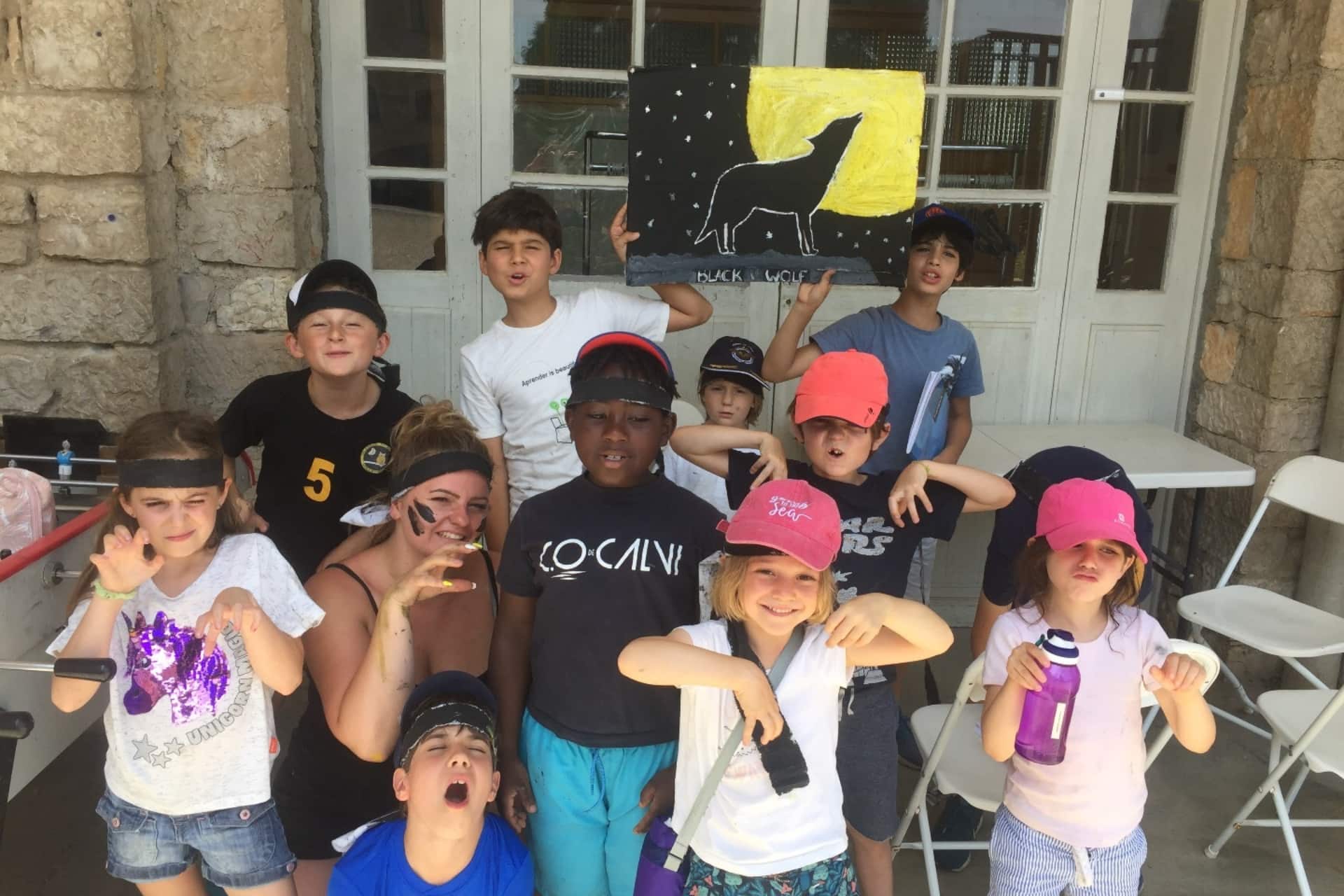 Enfants participant à un atelier créatif sur le loup du Gévaudan en colonie de vacances.