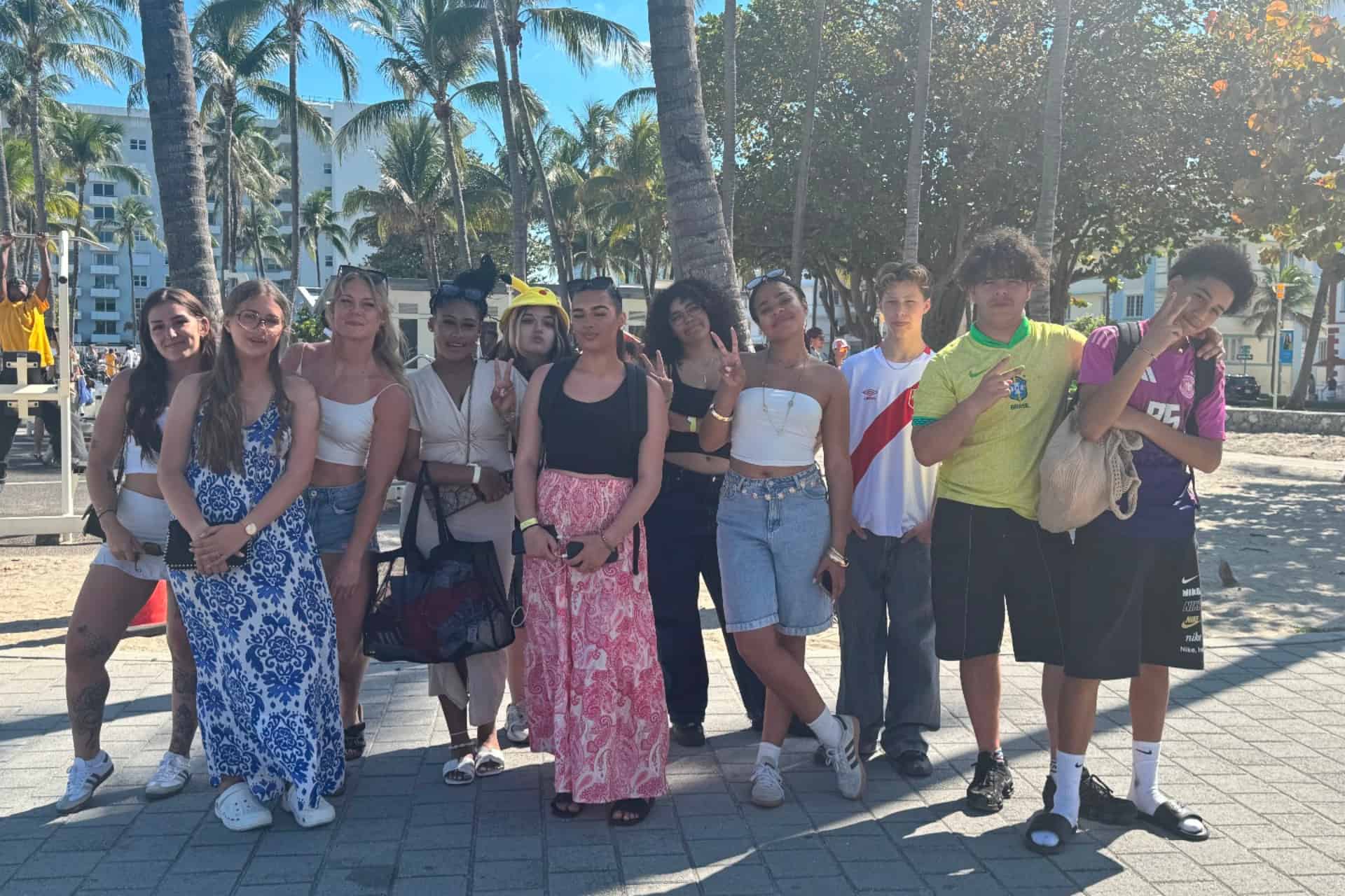 Groupe d'adolescents en colonie de vacances à Miami sur la promenade de Miami Beach bordée de palmiers