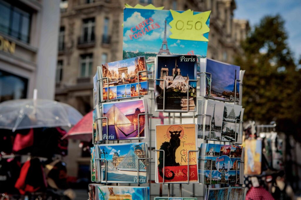 Rack of colorful Paris postcards for sale on a street stall, classic souvenirs from France.