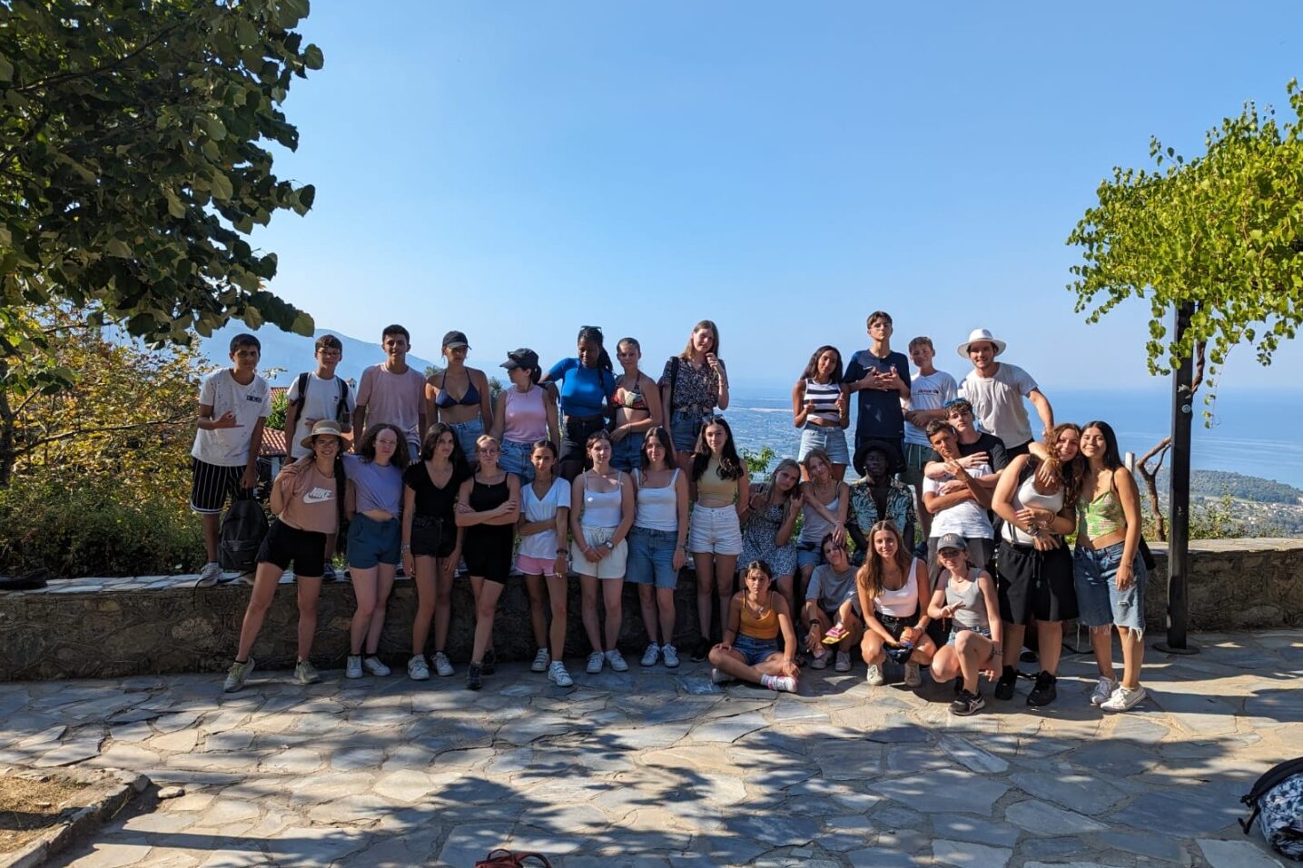 Groupe d’adolescents en excursion pendant la colonie de vacances CEI en Grèce avec vue sur la mer Égée