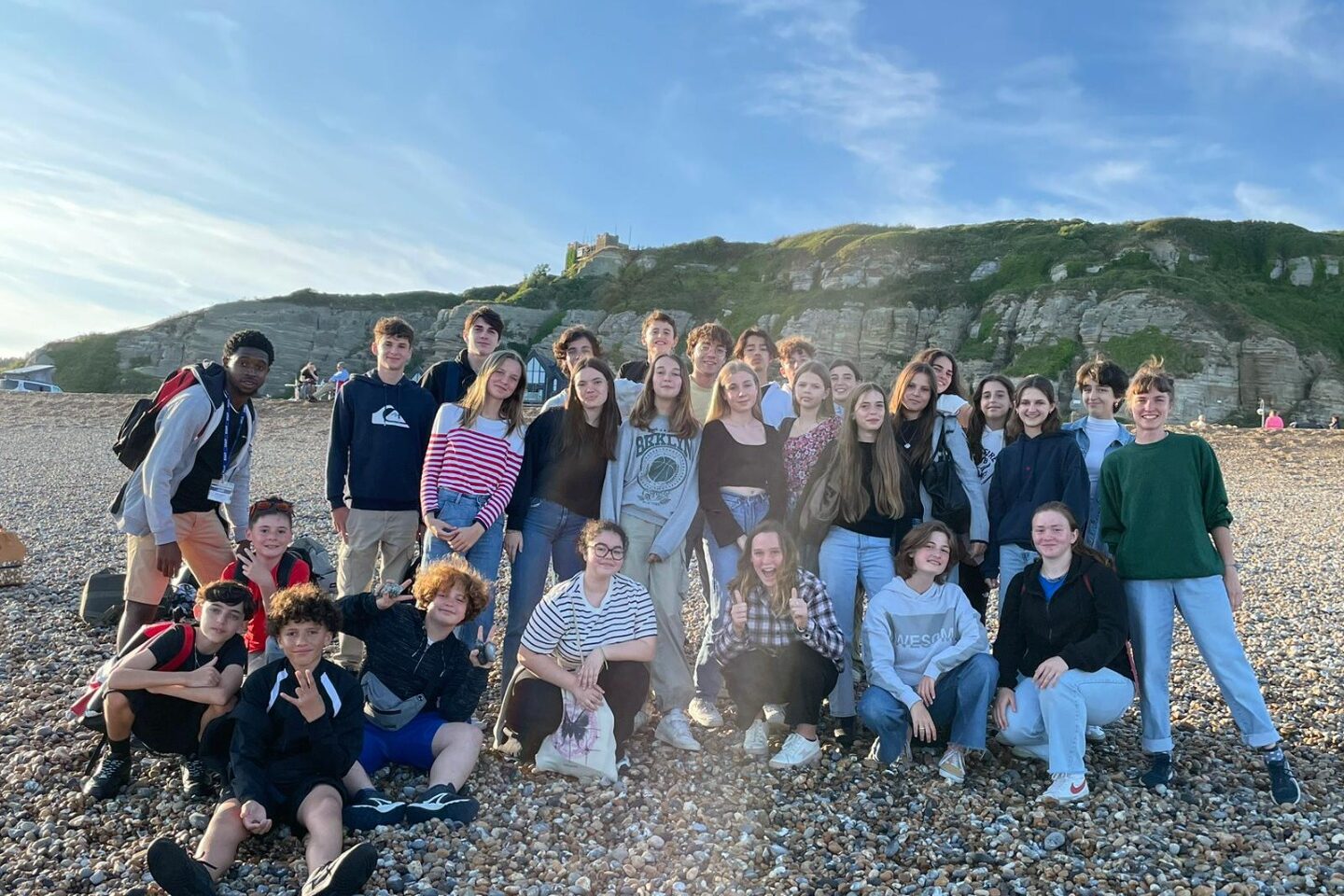Les jeunes du séjour linguistique à Hastings partagent un moment convivial sur la plage, après une journée d'activités et de découvertes, dans le cadre d'une immersion en famille d'accueil.