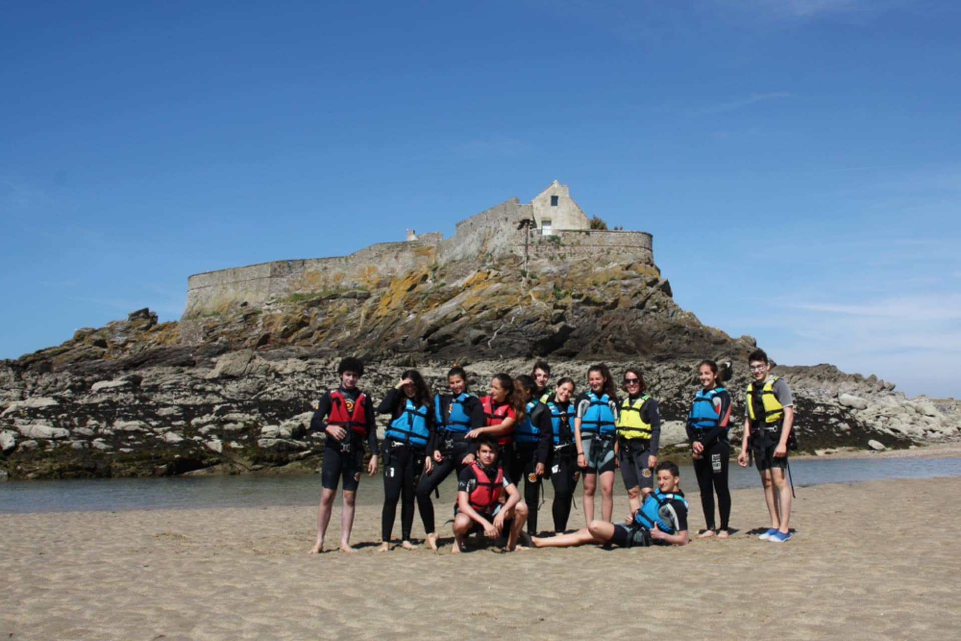 Groupe d’adolescents sur une plage de Bretagne pendant un séjour linguistique voile et activités.