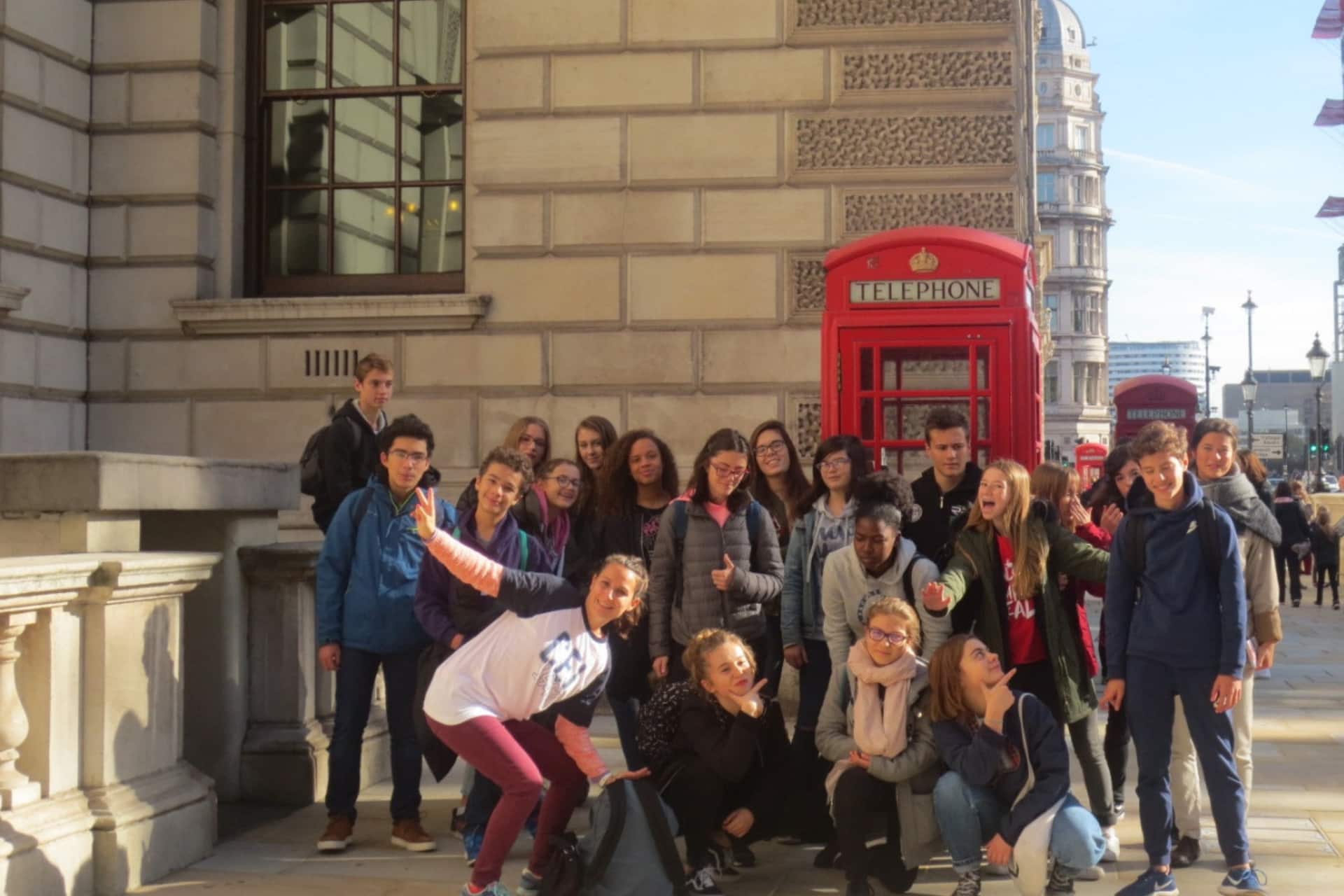 Groupe de jeunes devant une cabine téléphonique rouge à Londres