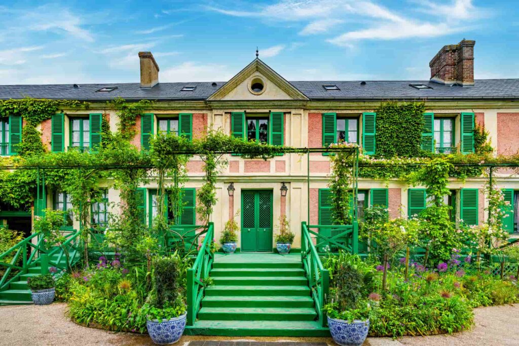 Claude Monet's colourful house in Giverny surrounded by flowers and lush gardens