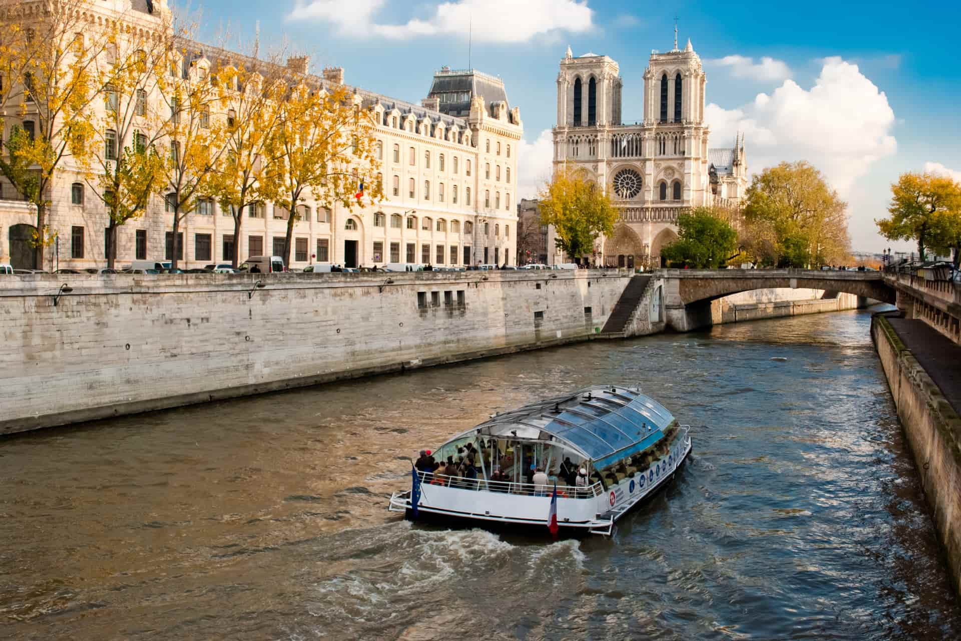 Sightseeing boat cruising along the Seine River near historic Parisian buildings