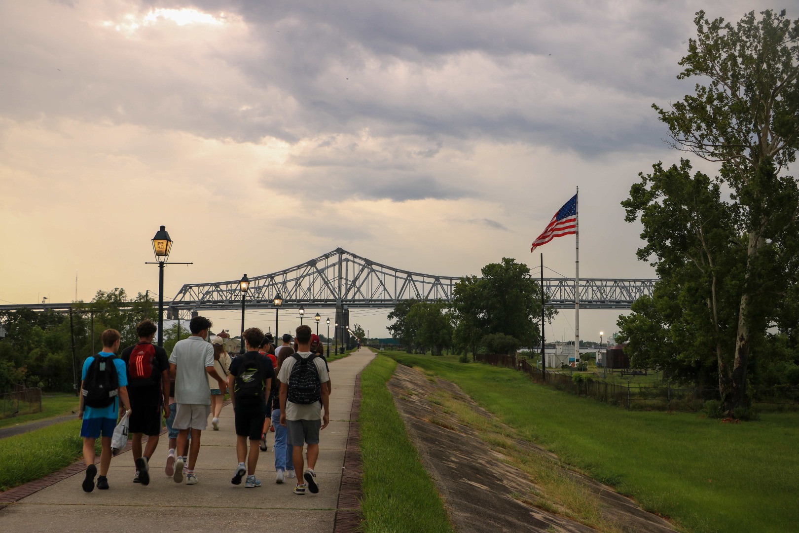 Adolescents en marche avec drapeau américain et pont au loin à Los Angeles